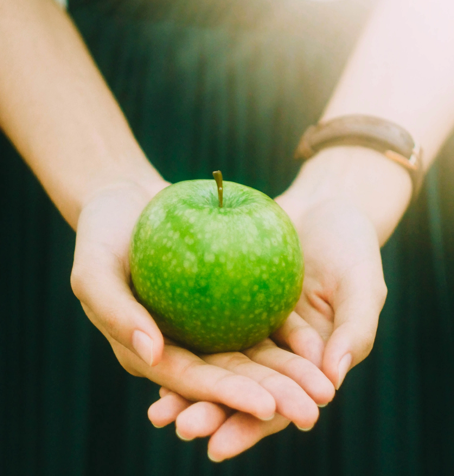 a person holding a green apple