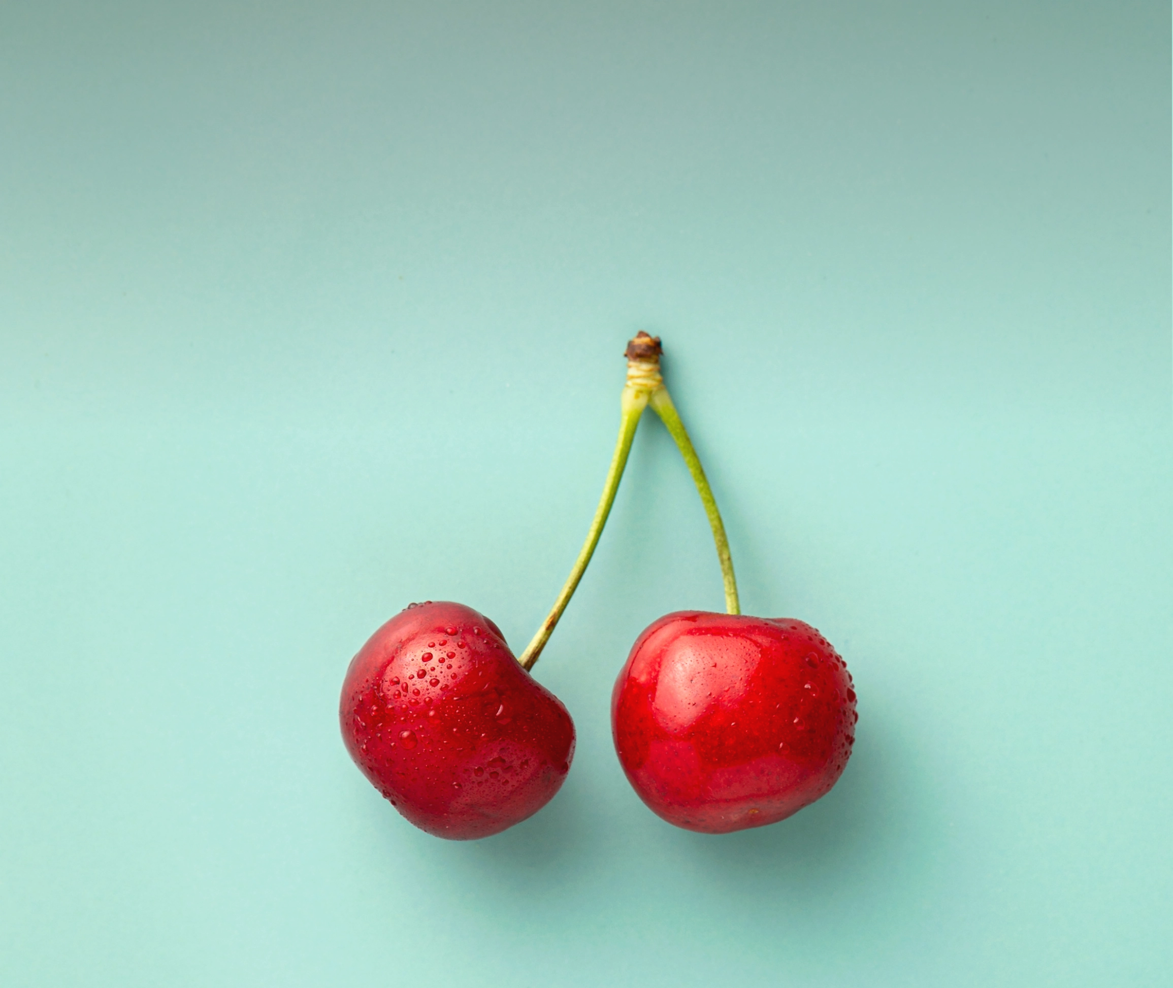 a pair of cherries on a blue background